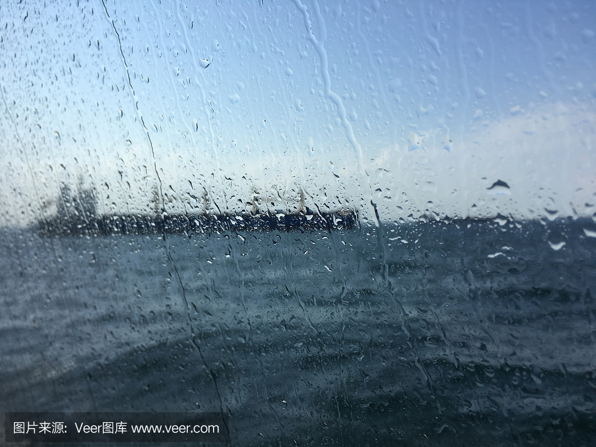 在潮濕的窗戶(hù)后面的海上油輪背景模糊圖像